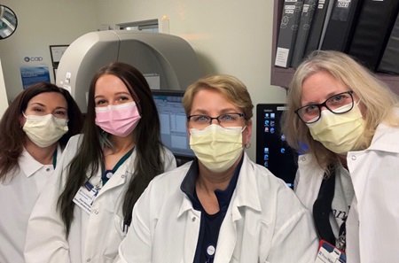Alison Steinmiller standing with three colleagues in the lab